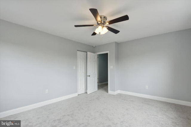 empty room with ceiling fan and light colored carpet