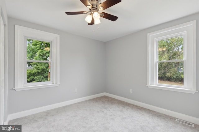 carpeted spare room featuring ceiling fan