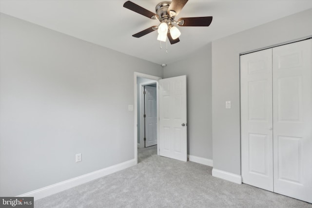 unfurnished bedroom with ceiling fan, light colored carpet, and a closet