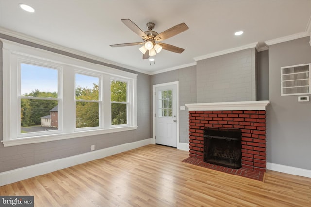 unfurnished living room featuring crown molding, light hardwood / wood-style floors, ceiling fan, and a brick fireplace