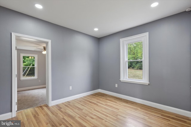 spare room featuring light wood-type flooring, a healthy amount of sunlight, and ceiling fan