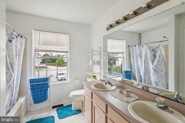 full bathroom featuring a wealth of natural light, shower / bath combo, vanity, and toilet