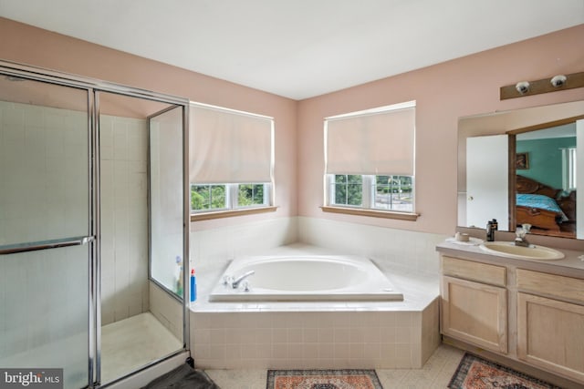 bathroom featuring shower with separate bathtub, vanity, and tile patterned floors