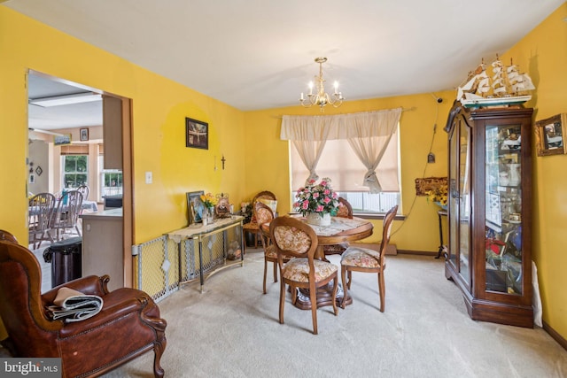 carpeted dining area featuring a chandelier and plenty of natural light