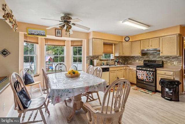 kitchen with black gas stove, light brown cabinets, and a wealth of natural light