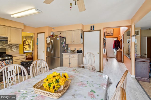 kitchen featuring ceiling fan, tasteful backsplash, stainless steel appliances, light brown cabinetry, and light hardwood / wood-style floors