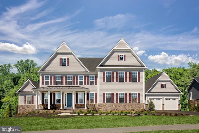 view of front of property featuring a front yard, a garage, and a porch