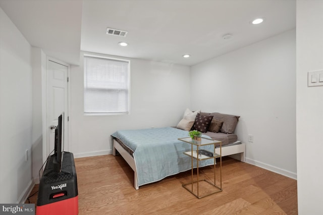 bedroom with baseboards, visible vents, wood finished floors, and recessed lighting