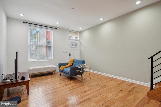 living area featuring light wood-style flooring, baseboards, and recessed lighting