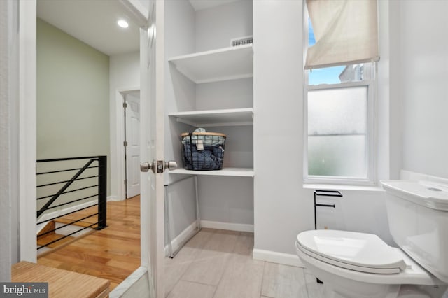 bathroom featuring hardwood / wood-style flooring and toilet