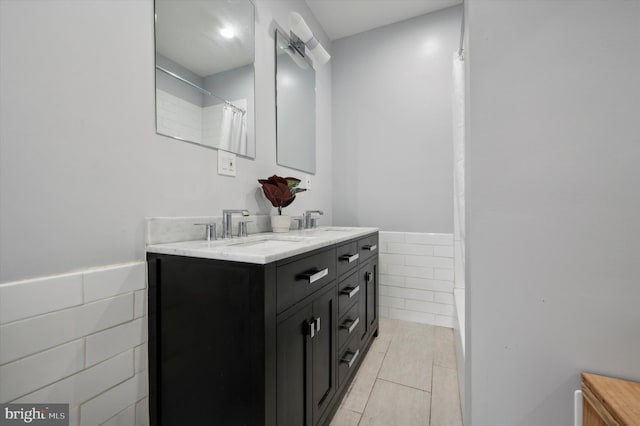 bathroom with walk in shower, vanity, tile walls, and tile patterned flooring