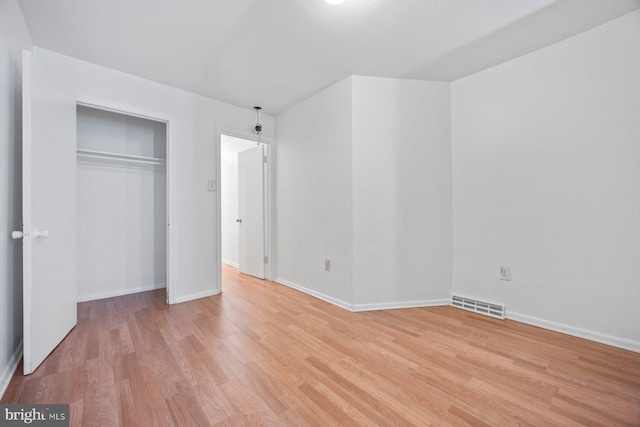 unfurnished bedroom featuring light hardwood / wood-style flooring and a closet