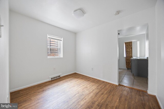 unfurnished room with hardwood / wood-style flooring