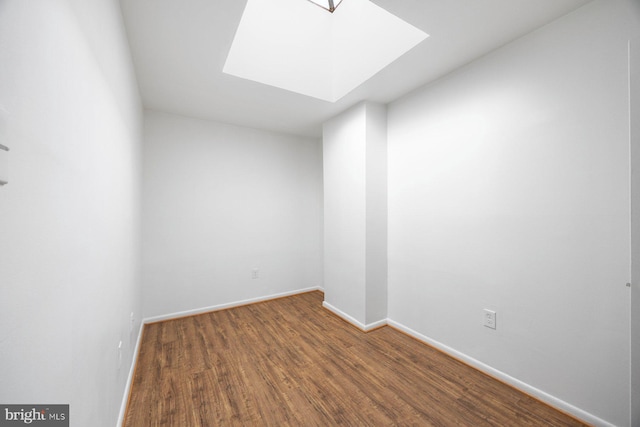 empty room featuring hardwood / wood-style floors and a skylight