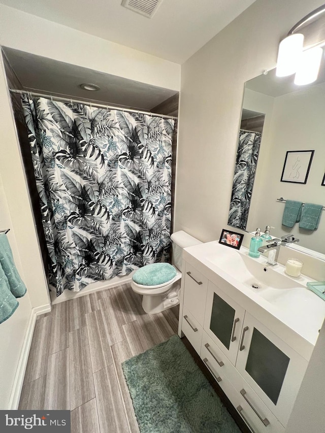 bathroom featuring vanity, hardwood / wood-style floors, and toilet