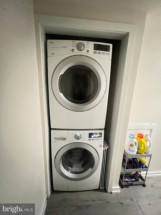 laundry room with stacked washing maching and dryer