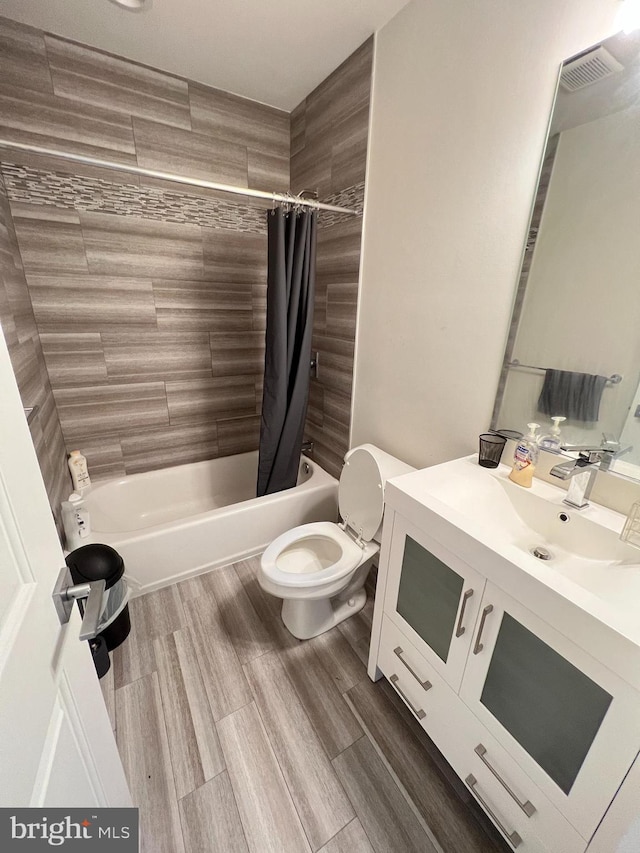 full bathroom featuring shower / bathtub combination with curtain, wood-type flooring, vanity, and toilet