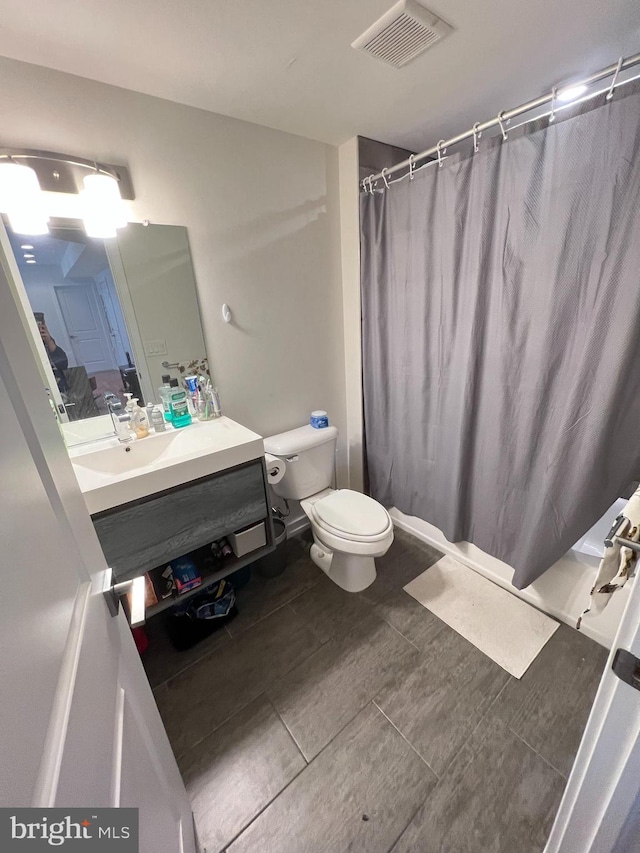 bathroom featuring a shower with curtain, vanity, toilet, and tile patterned floors