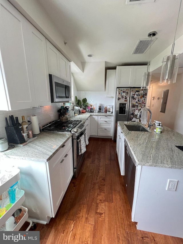 kitchen with white cabinets, sink, decorative light fixtures, stainless steel appliances, and dark hardwood / wood-style floors