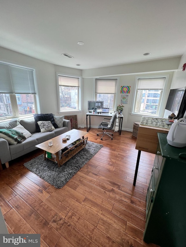 living room featuring dark hardwood / wood-style floors and plenty of natural light