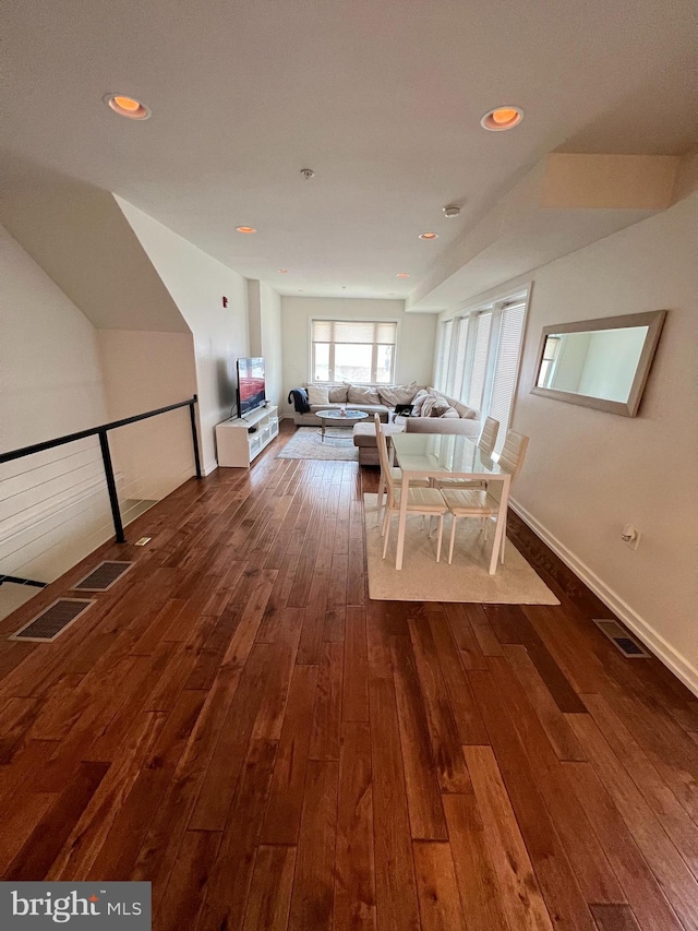 unfurnished dining area with a skylight and dark hardwood / wood-style floors