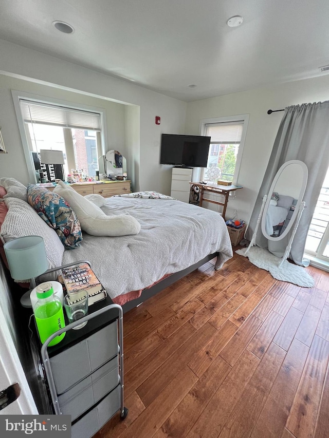 bedroom with access to outside and dark hardwood / wood-style floors