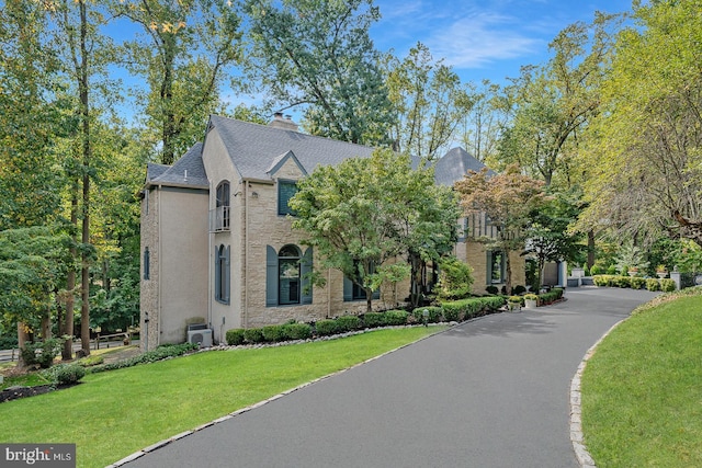 view of front of house featuring a balcony and a front yard