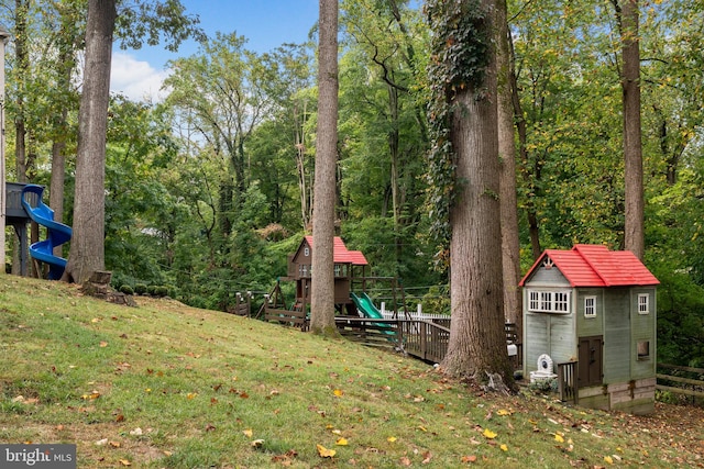 view of yard featuring a playground and an outbuilding