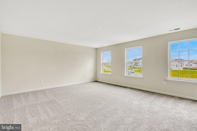 empty room with visible vents, baseboards, and carpet flooring