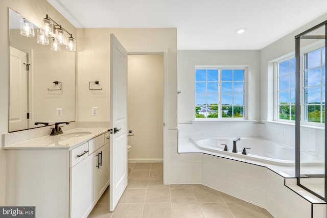 full bath with tile patterned floors, a garden tub, toilet, baseboards, and vanity