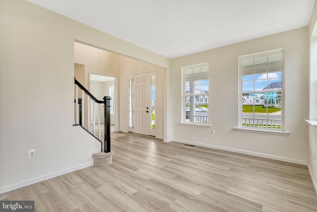 entryway featuring stairs, wood finished floors, and baseboards