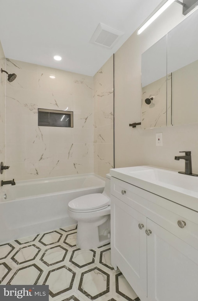 full bathroom featuring tile patterned floors, tiled shower / bath, vanity, and toilet