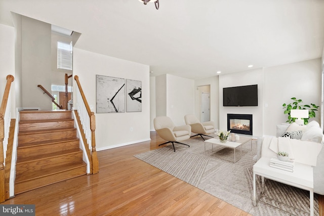 living room with a multi sided fireplace and hardwood / wood-style floors