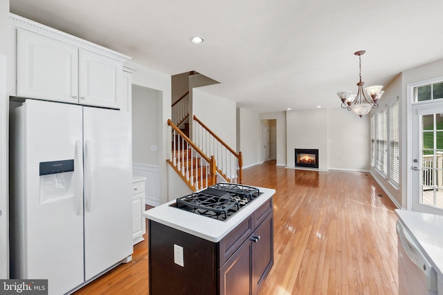 kitchen with white cabinetry, dishwasher, light wood-type flooring, black gas cooktop, and white fridge with ice dispenser