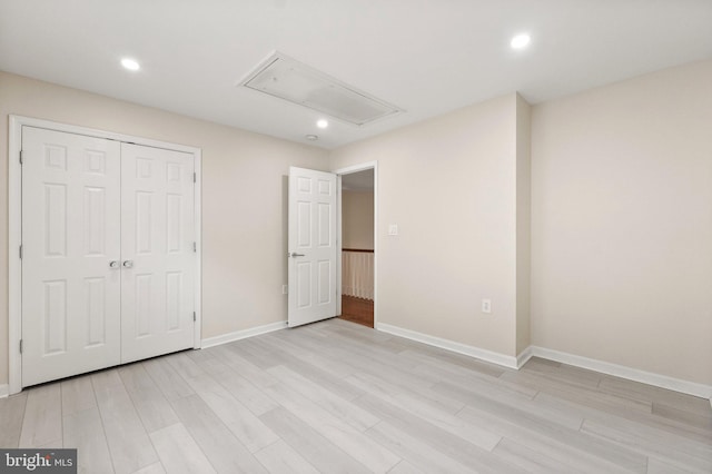 unfurnished bedroom with a closet and light hardwood / wood-style floors