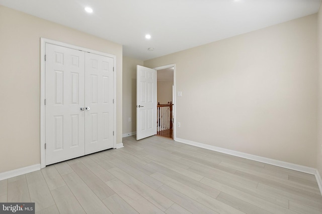 unfurnished bedroom featuring a closet and light hardwood / wood-style floors