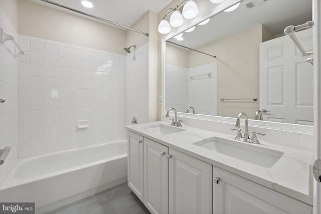 bathroom featuring tiled shower / bath and vanity