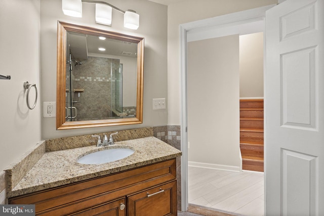 bathroom with wood-type flooring, vanity, and an enclosed shower