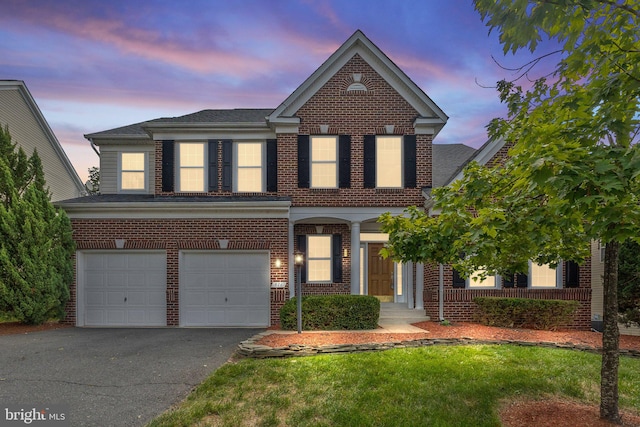 front of property with a yard and a garage