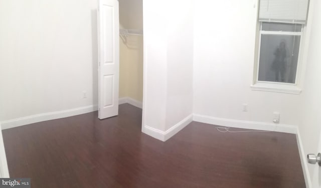 unfurnished bedroom featuring dark hardwood / wood-style flooring and a closet