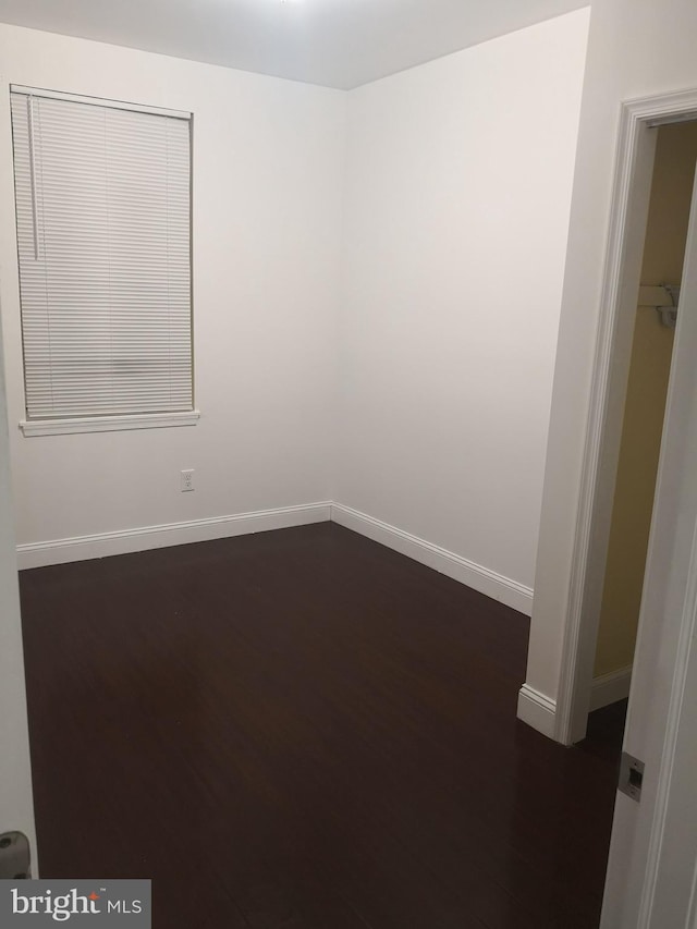 empty room with dark hardwood / wood-style flooring