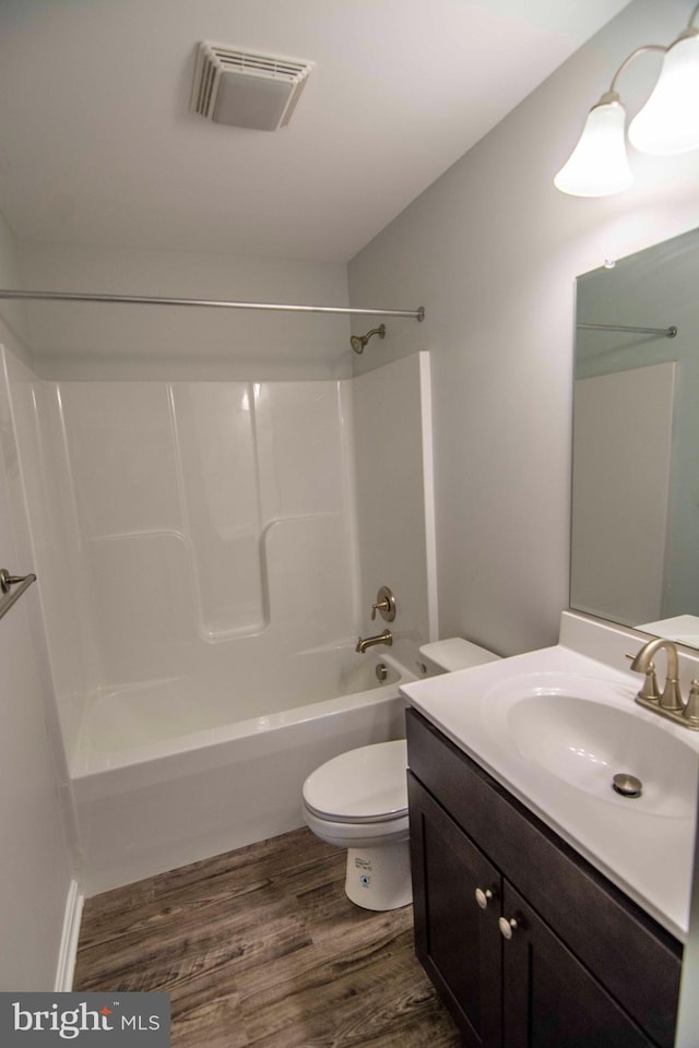 full bathroom featuring vanity, wood-type flooring, shower / bathtub combination, and toilet