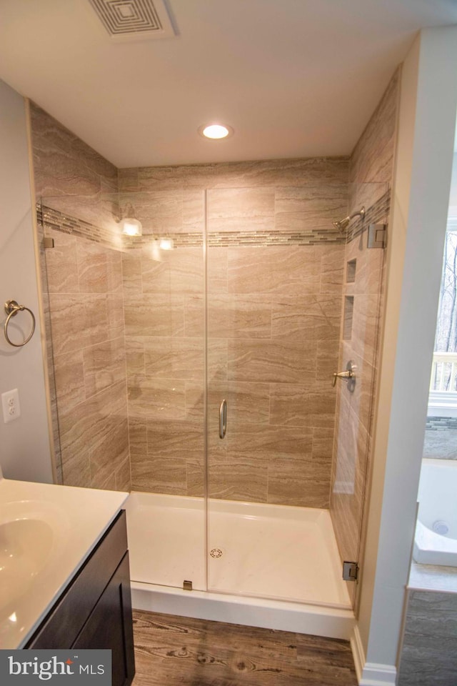 bathroom with vanity, a shower with door, and hardwood / wood-style floors