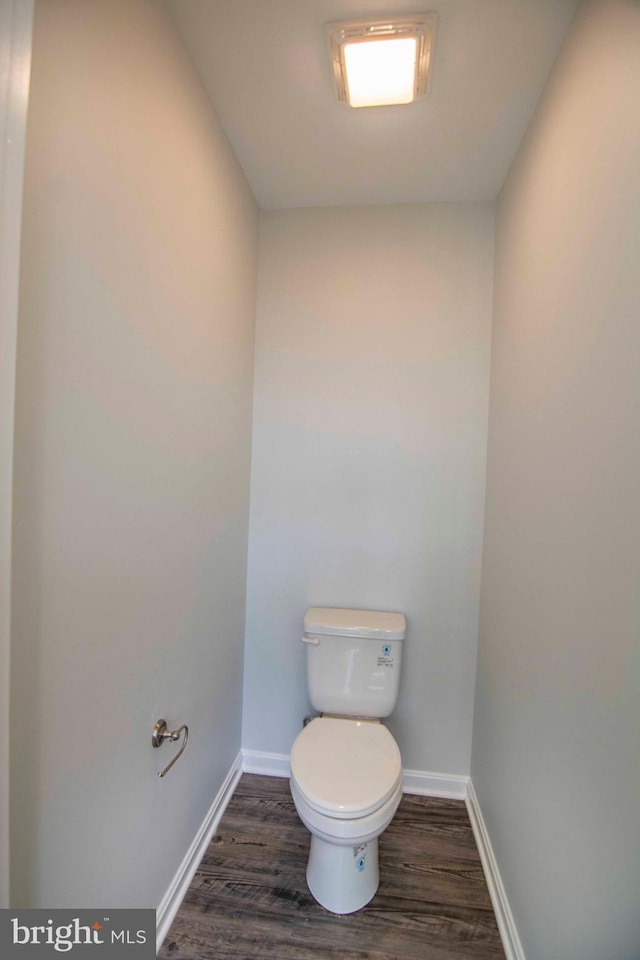 bathroom featuring wood-type flooring and toilet