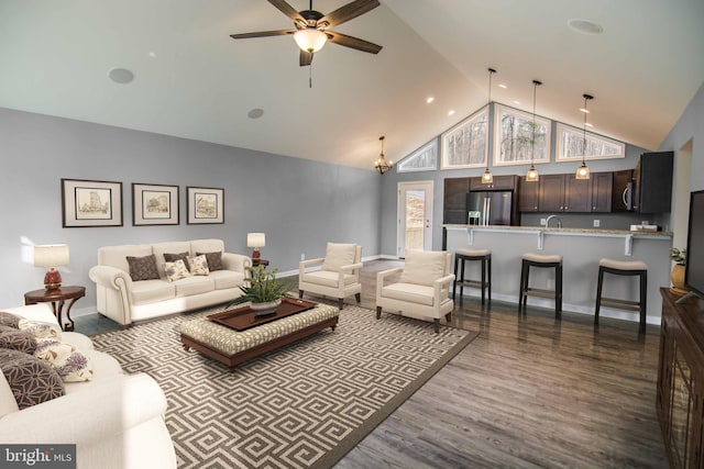 living room with dark hardwood / wood-style flooring, ceiling fan with notable chandelier, and high vaulted ceiling