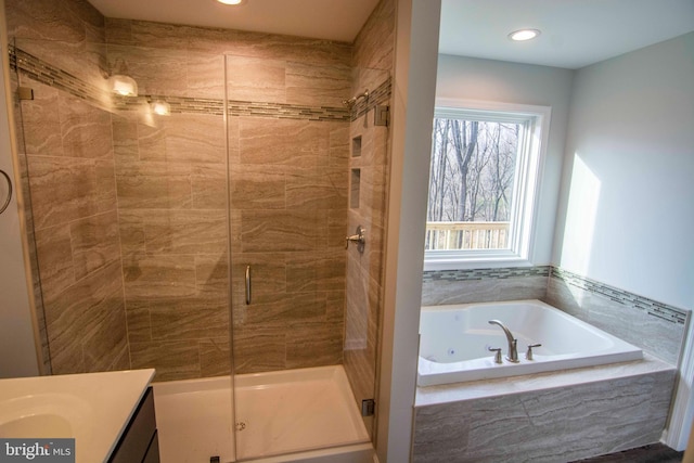 bathroom featuring vanity and shower with separate bathtub