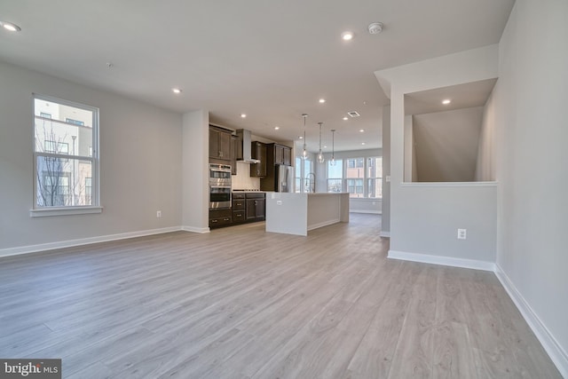 unfurnished living room with sink and light hardwood / wood-style flooring