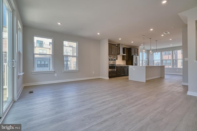 unfurnished living room featuring light hardwood / wood-style flooring and sink