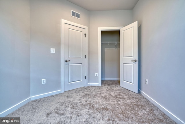 unfurnished bedroom with light carpet and a closet