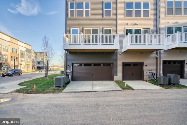 exterior space with a balcony, central air condition unit, and a garage